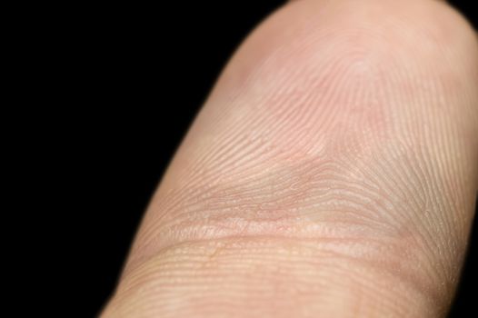 Close-up of fingerprint on index finger isolated on black background