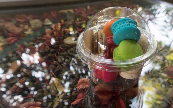 French macarons colorful on glass table with coffee seeds and seeds plant backgrond,, selective focus