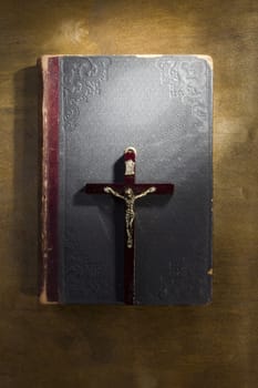 Ancient book and crucifix on a wooden table
