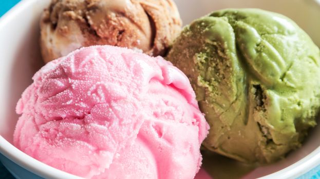 Closeup ice cream strawberry, greentea ,chocolate in the bowl on blue background
