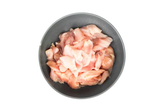 Top view pieces of raw chicken fillet in bowl on white background, raw material for cooking