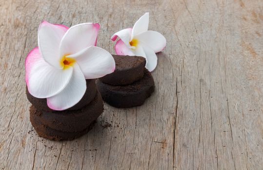 Closeup Plumeria sweet color and coffee ground on old wood background, skin care beauty and spa relax concept