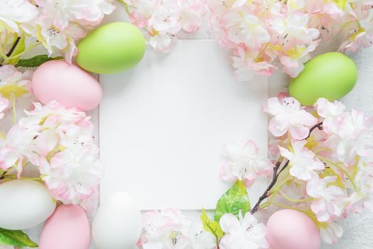 Beautiful delicate Easter frame with pink cherry flowers and multicolored Easter eggs