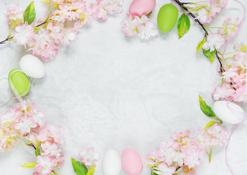 Beautiful delicate Easter composition with pink cherry flowers and multicolored Easter eggs