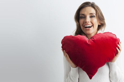 Beautiful woman with red pillow heart, valentine's day concept