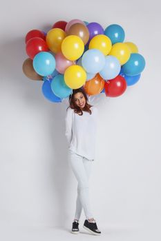 Happy woman with many colorful balloons