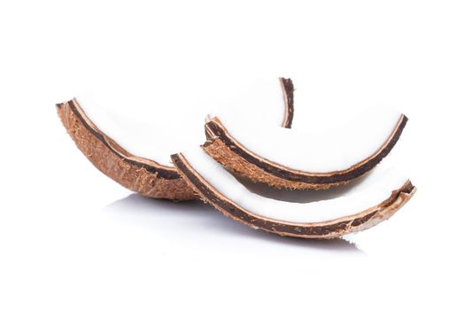 Pieces of coconut shell broken into pieces and stacked on white background