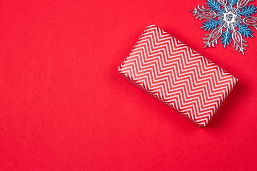 Christmas gift, toy, Snowflakes in the foreground. red background