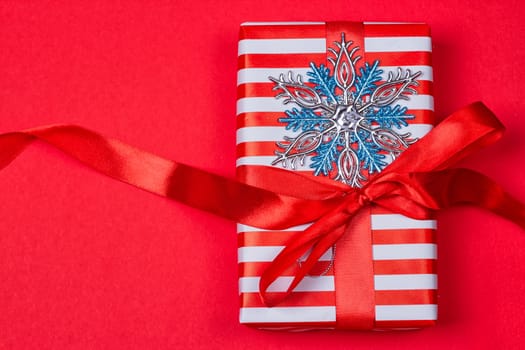 Christmas gift, toy, Snowflakes in the foreground. red background