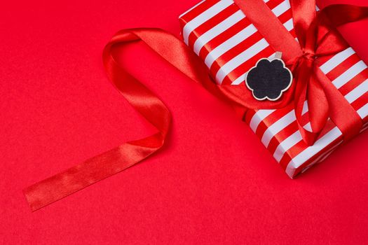 gift with red bow on red background. Free space for your text.