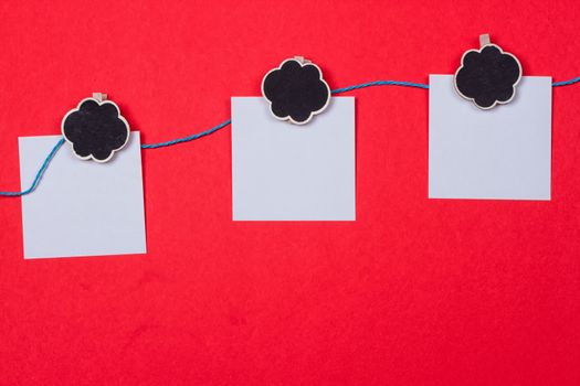 Clothespins, papers with a place for writing on a red background