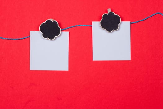 Clothespins, papers with a place for writing on a red background