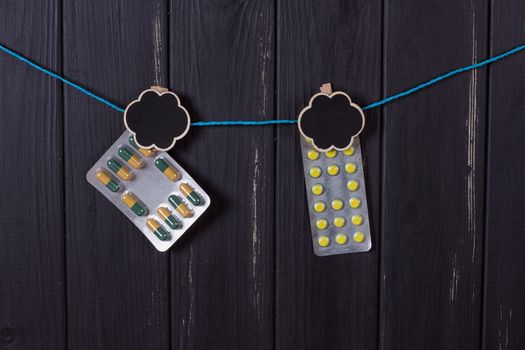 tablets on a clothespin on a black wooden fence