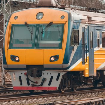 Yellow modern passenger electric train moving at the old terminal