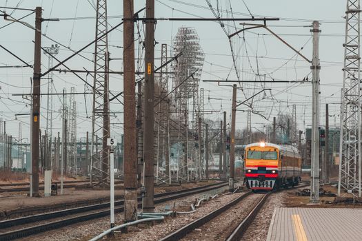 Old yellow passenger diesel train moving at the terminal