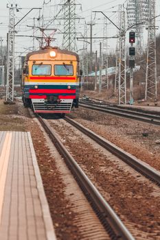 Old yellow passenger electric train driving at the terminal