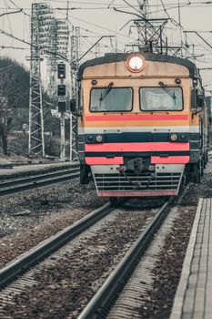 Old yellow passenger electric train driving at the terminal