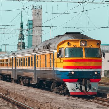 Old yellow passenger diesel train moving at the terminal