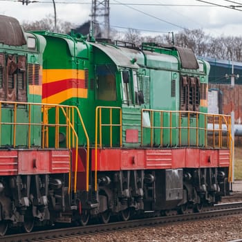 Green diesel cargo locomotive. Freight train in action