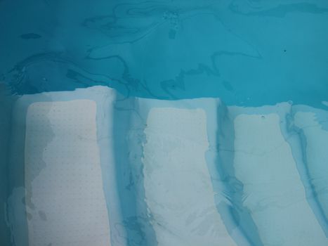 Abstract of Four White Underwater Stairs in Swimming Pool