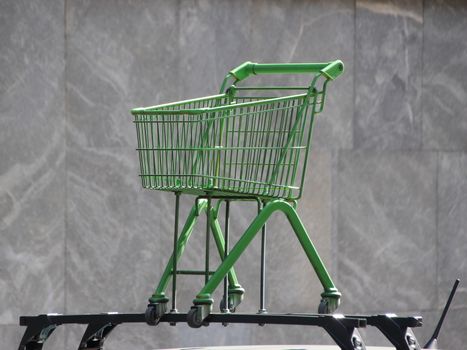 Green Shopping Trolley Isolated Mounted on Car Rooftop