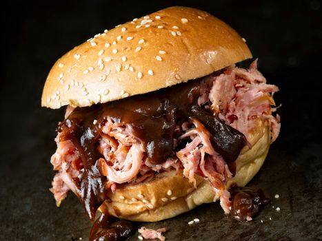 close up of rustic american barbecued pulled pork sandwich