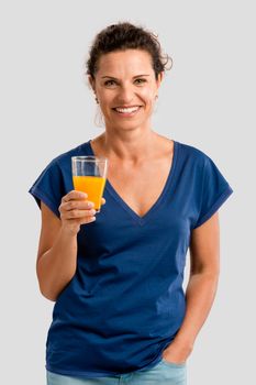 Middle aged woman holding a glass with orange juice