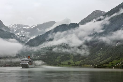 Cruise ship docked in Geiranger in a foggy day, Norway