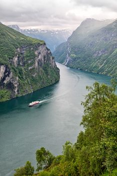 Cruise ship sailing in the fjord near Geiranger seen from above, Norway