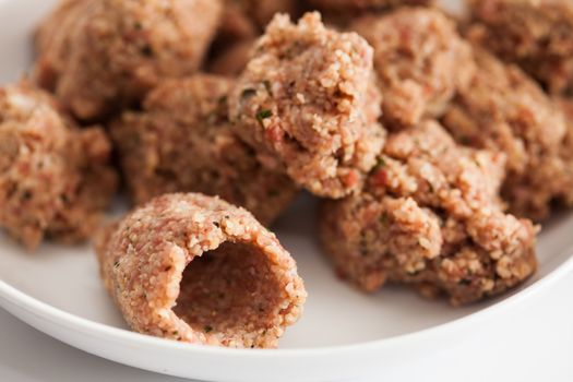 Step by step Levantine cuisine kibbeh preparation : Balls of kibbeh meat mix and one empty kibbeh