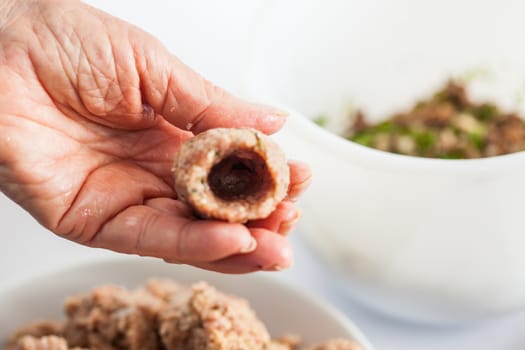 Step by step Levantine cuisine kibbeh preparation : Close up of a senior woman hands shaping a kibbeh