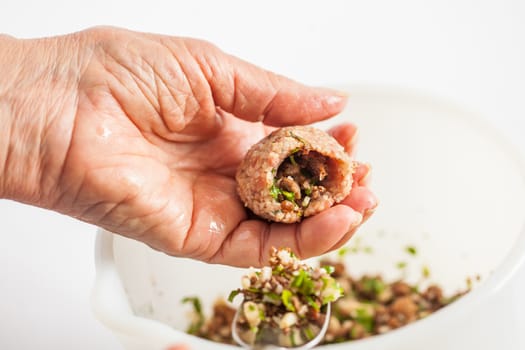Step by step Levantine cuisine kibbeh preparation : Close up of a senior woman hands filling a kibbeh