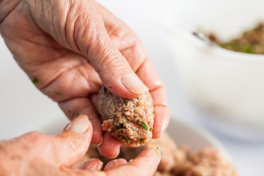 Step by step Levantine cuisine kibbeh preparation : Close up of a senior woman hands shaping a kibbeh