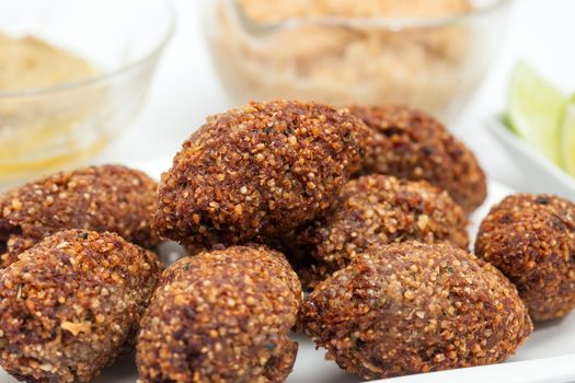 Step by step Levantine cuisine kibbeh preparation : Ready fried kibbeh served with tahini and hummus