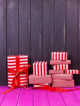 Gift boxes with ribbons and christmas decor on wooden background