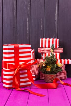 Gift boxes and small decorated Christmas tree on black background