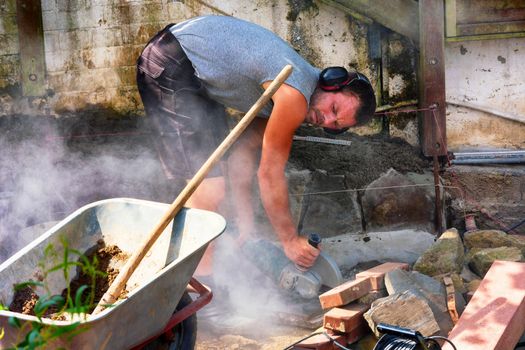 Worker cuts the bricks with a cut-off grinder.