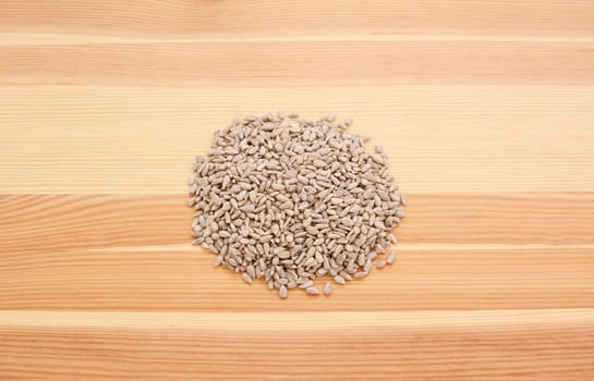 Hulled sunflower seed hearts on a wooden background, pine wood grain