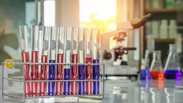 Different laboratory test tubes with colored liquid and with reflection