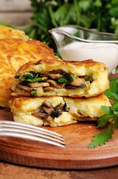 Potato cakes (zrazy) Stuffed mushrooms with herbs of the table with sour cream