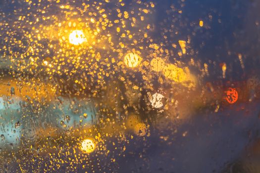 defocused view on airplane wing through passenger window with rain drop