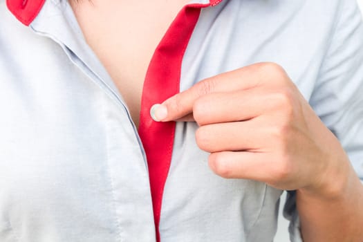 Woman hand hold a button of her shirt