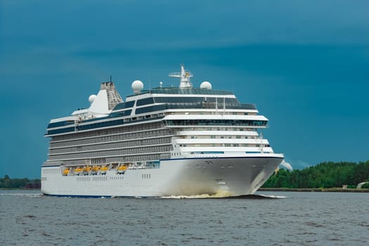 White cruise liner moving to the sea at cloudy day