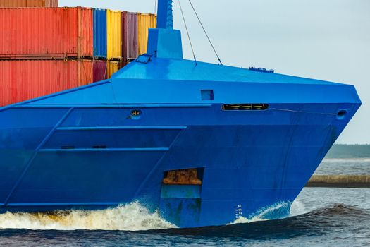 Blue cargo container ship fully loaded underway