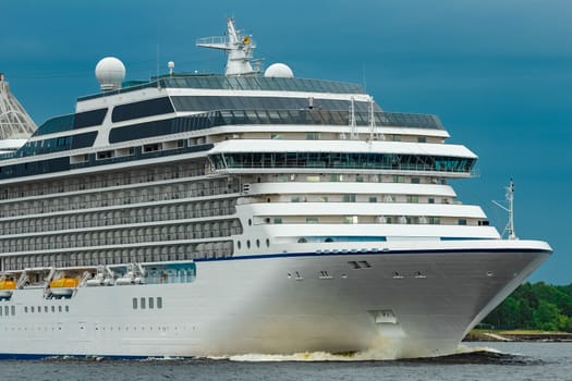 White cruise liner moving to the sea at cloudy day