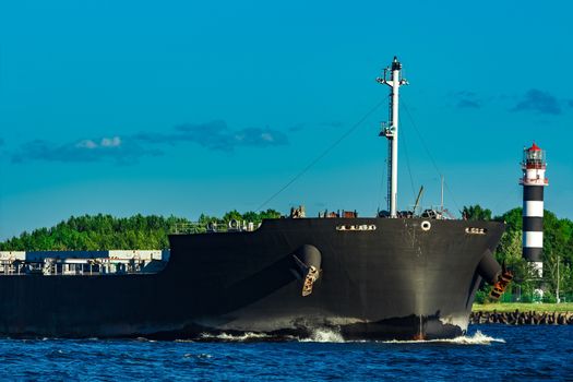 Black cargo ship moving to Baltic sea at clear day