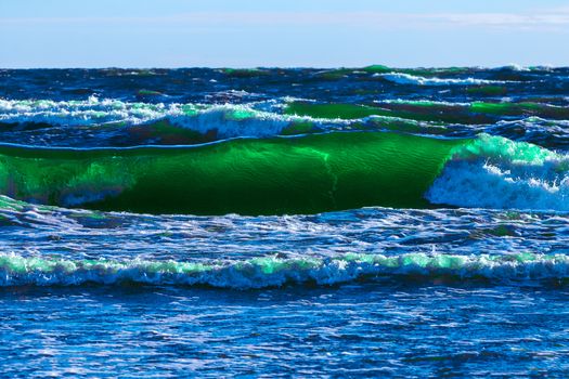 Summer ocean beach with green waves at sunny day