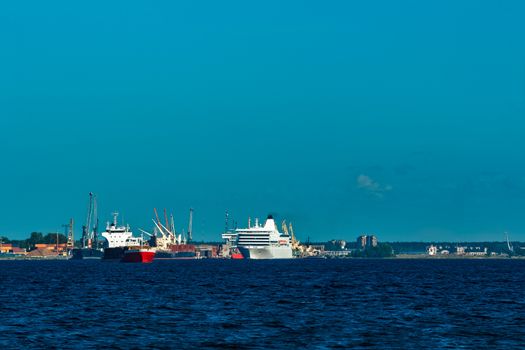 Red cargo ship fully loaded with wood moving at clear day