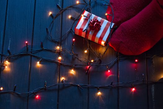 Woman feet in woollen socks and gifts Christmas holidays concept.