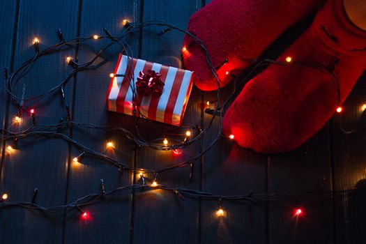 Woman feet in woollen socks and gifts Christmas holidays concept.